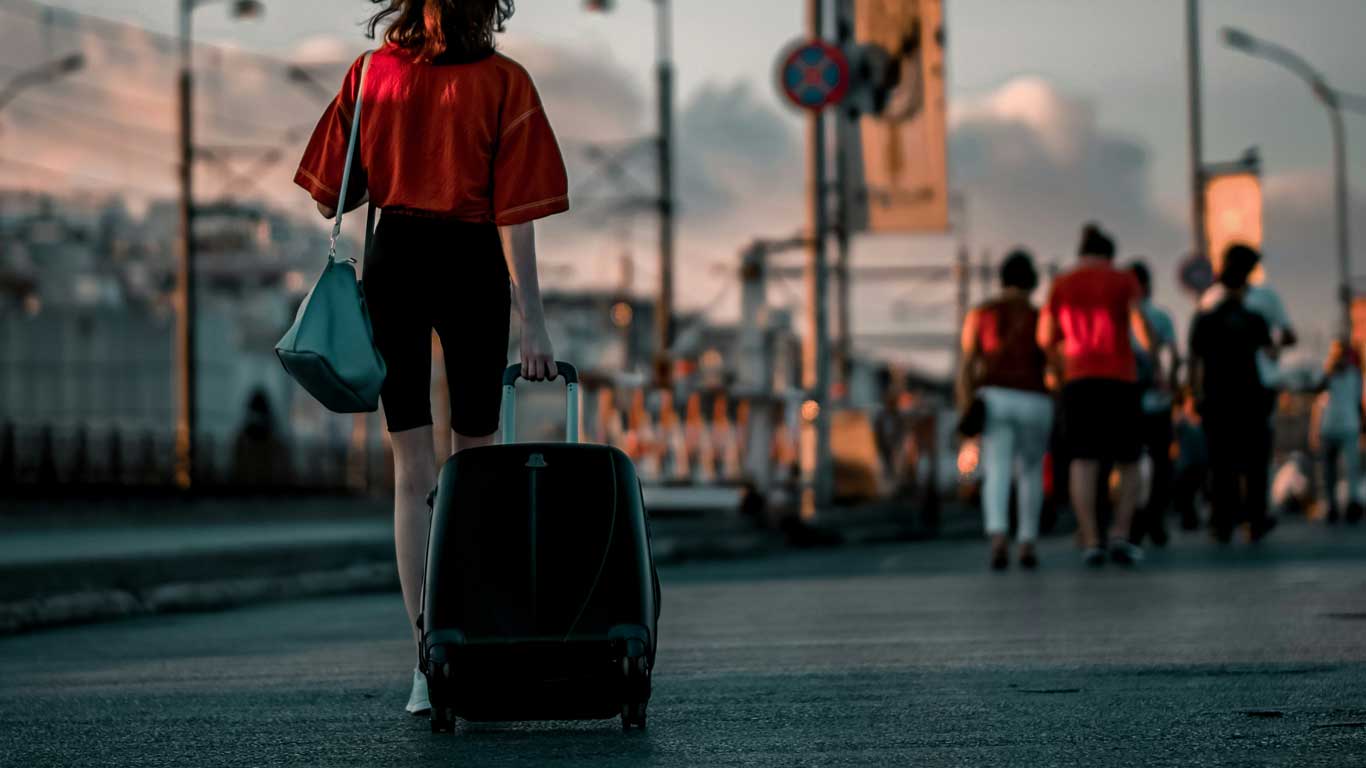 A woman pulling a suitcase for Europe in spring.