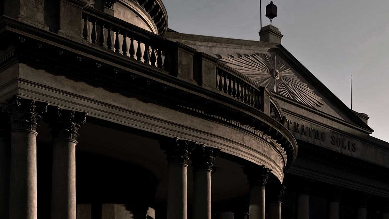 A view of Teatro Solís in Montevideo, showing its grand neoclassical facade with tall columns and intricate architectural details. The building's name is partially visible on the pediment, illuminated by soft evening light.