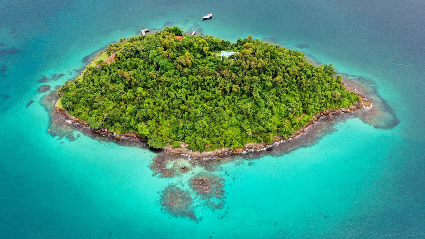 Aerial view of a small island covered by the Atlantic Forest, nestled in the turquoise ocean of Angra dos Reis, one of the best cities to visit in Rio de Janeiro.