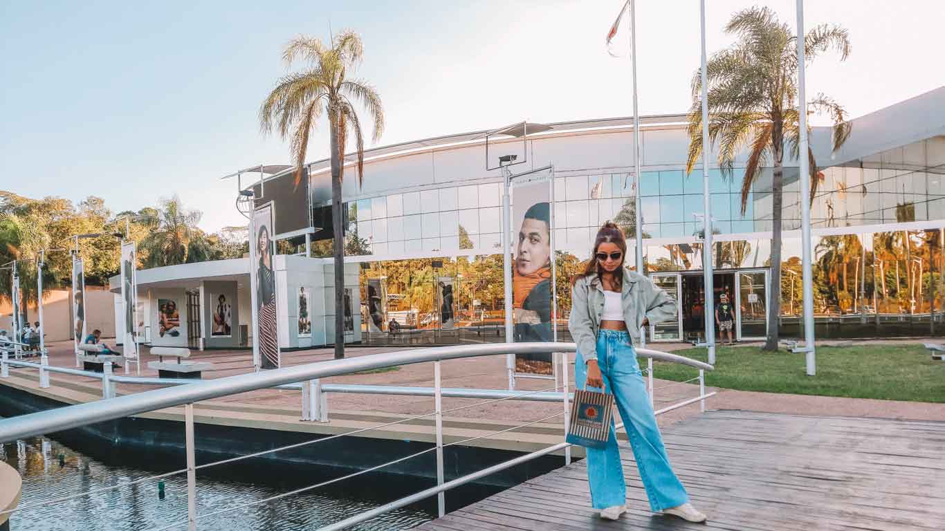 Woman posing in front of the Duty Free Puerto Iguazú, with shopping bags.