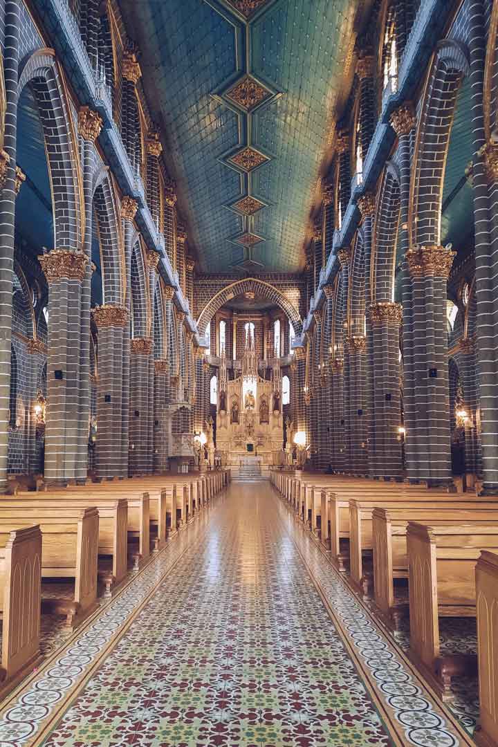 church-in-jardin Interior view of the Basilica of the Immaculate Conception in Jardín, showing its striking teal ceiling, striped columns with golden capitals, and symmetrical wooden pews leading to an ornate altar.