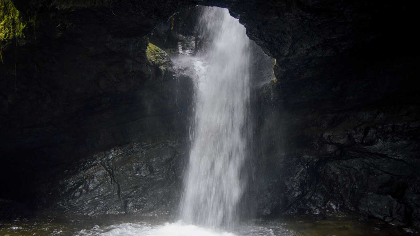 cueva-del-esplendor-jardin Water cascades through the mouth of the Cueva del Esplendor cave, creating a dramatic underground waterfall—one of the most adventurous things to do in Jardín, Colombia.