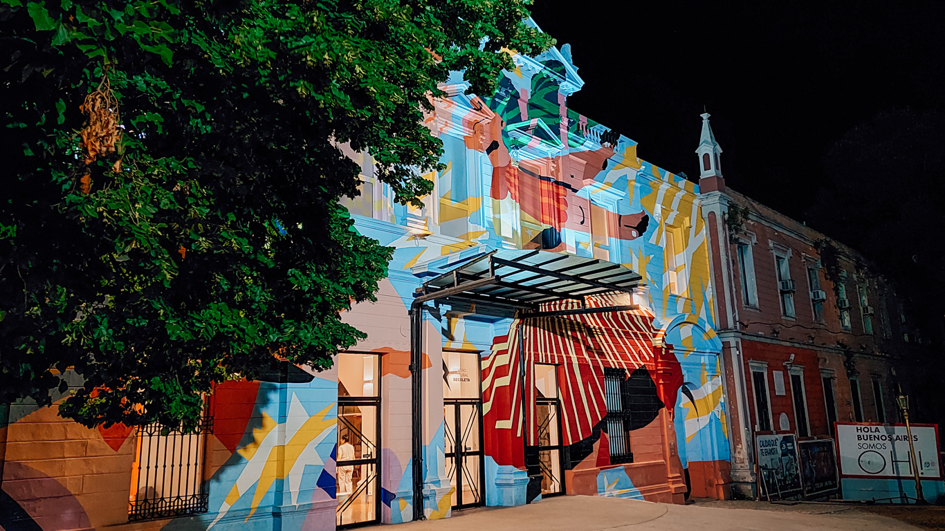 recoleta-cultural-center Vibrantly painted entrance to the Recoleta Cultural Center at night, lit up with bold, colorful murals.