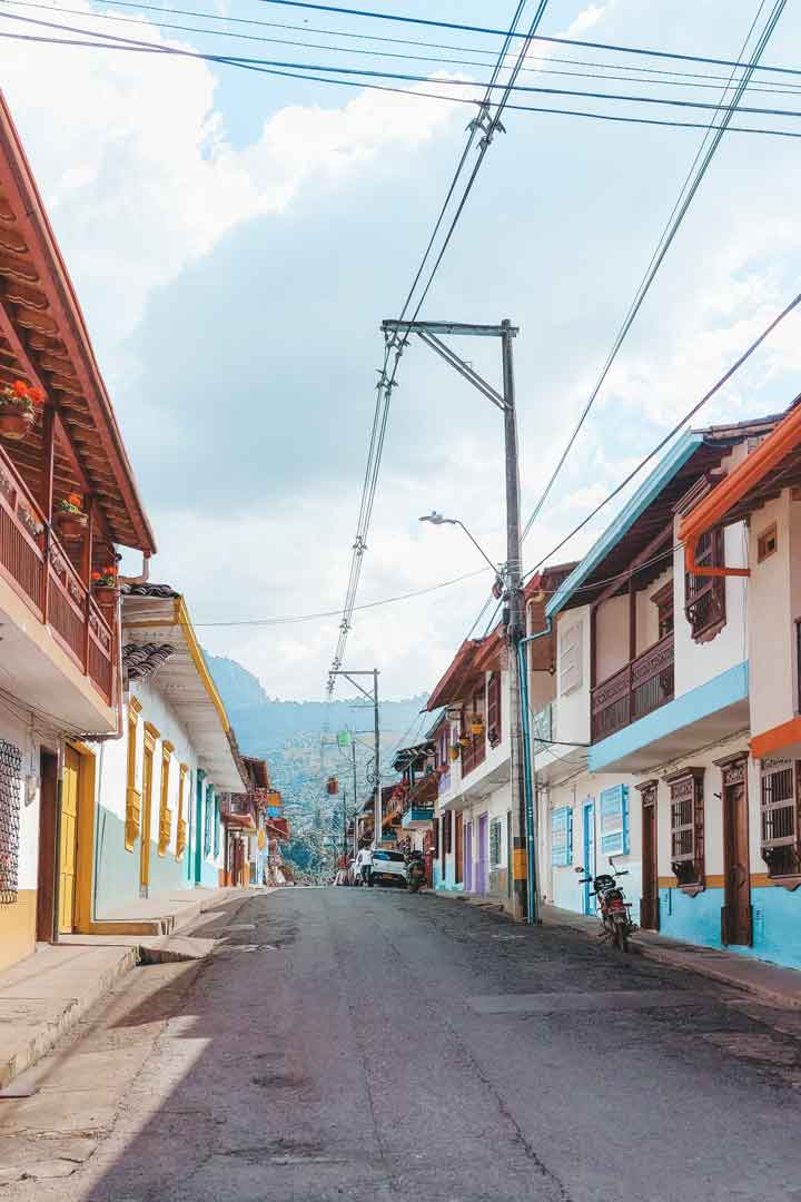 street-in-jardin A quiet, colorful street in Jardín, Colombia, lined with traditional balconies and set against a mountainous backdrop—exploring this charming town on foot is a highlight among things to do in Jardín, Colombia.