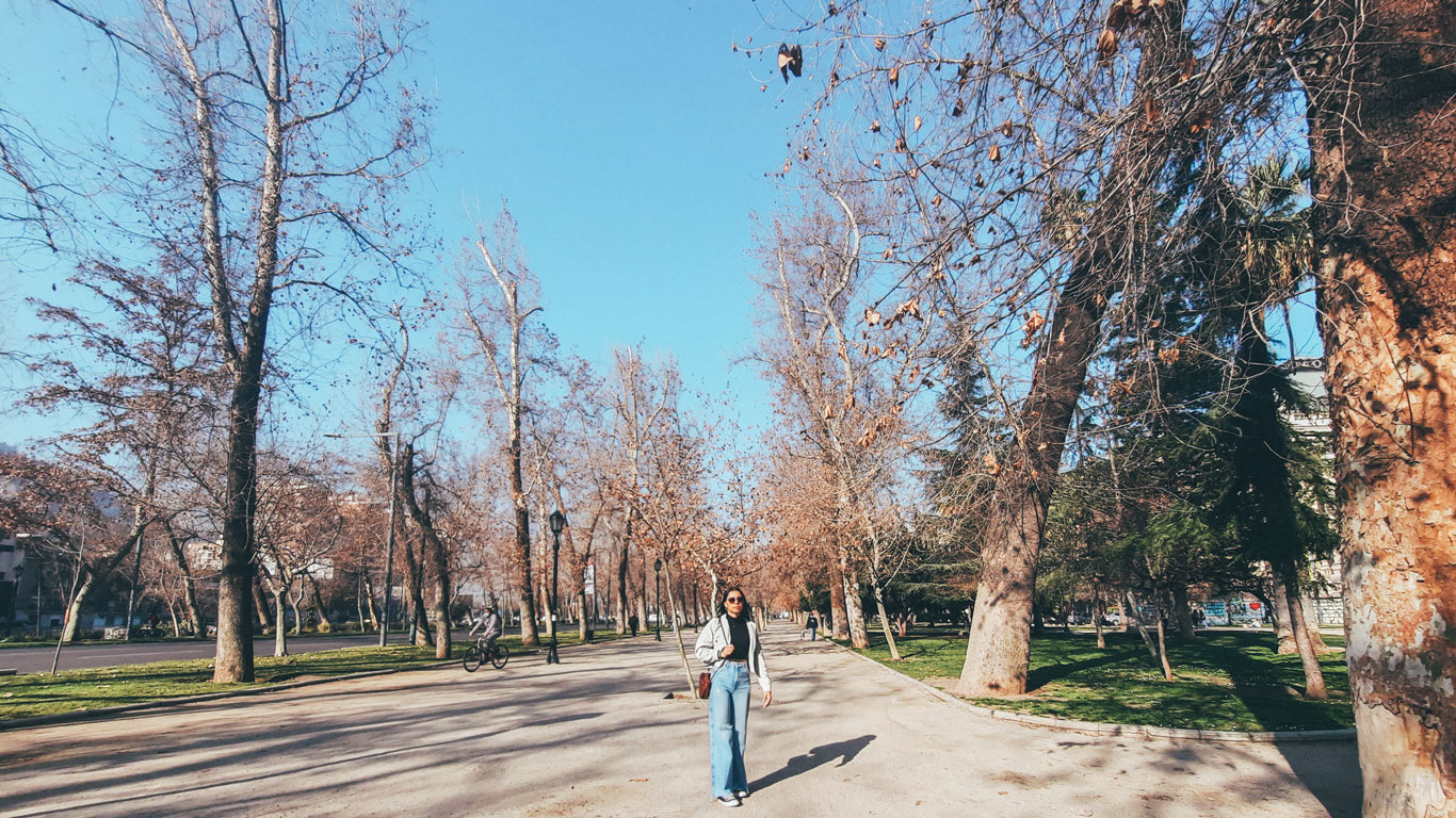 to-pack-for-santiago-in-snow A woman walks through Parque Forestal in Santiago on a crisp day, bundled in winter clothes — a typical outfit during the snow season in Santiago.