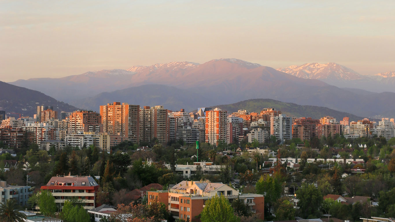 view-of-the-andes-mountains-from-santiago Cityscape of Santiago at golden hour with the Andes Mountains in the background, lightly dusted with snow — a subtle reminder of the snow season in Santiago.