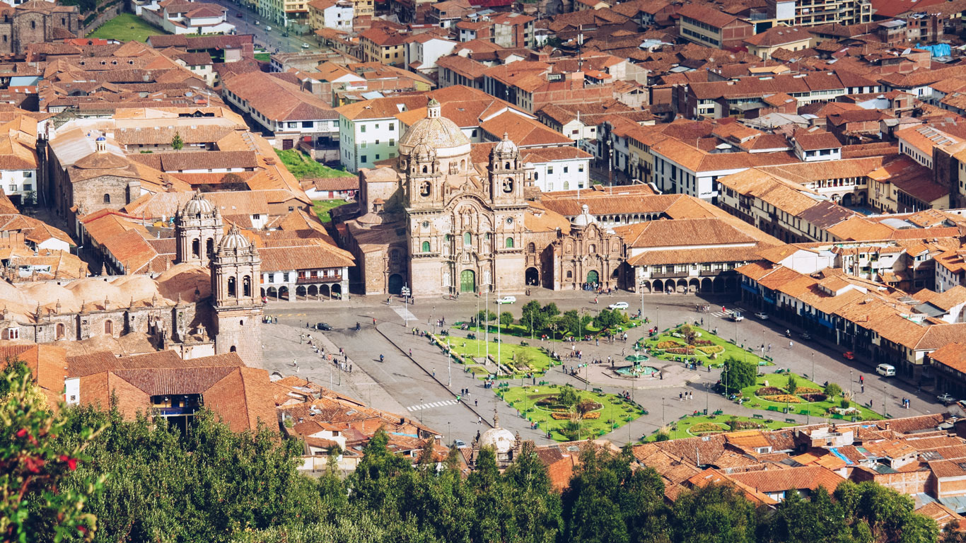 Aerial view of Cusco’s historic Plaza de Armas with its colonial churches and red-tiled rooftops—an essential stopover for visitors deciding where to stay in Machu Picchu and planning their journey through Peru’s Sacred Valley.